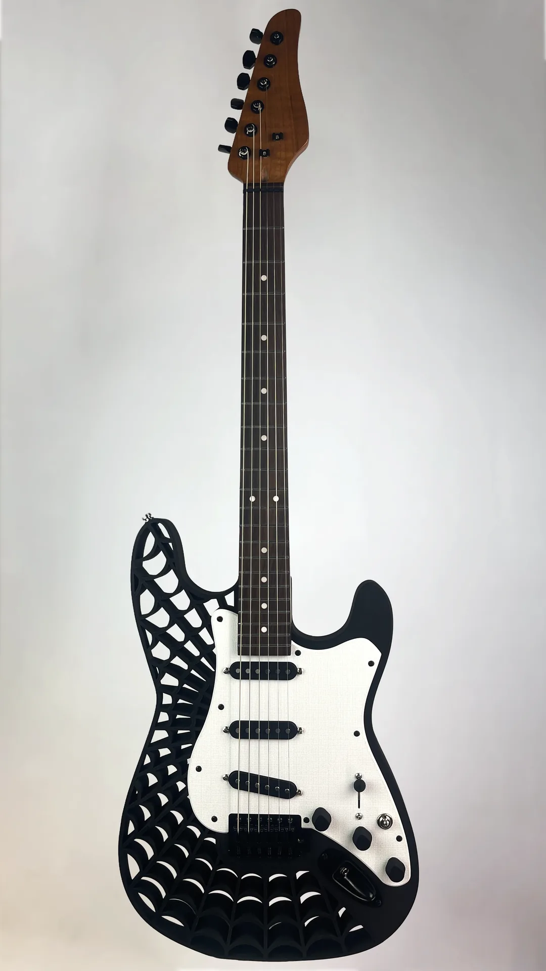 Black 3D-printed guitar with a web-pattern body and white pickguard